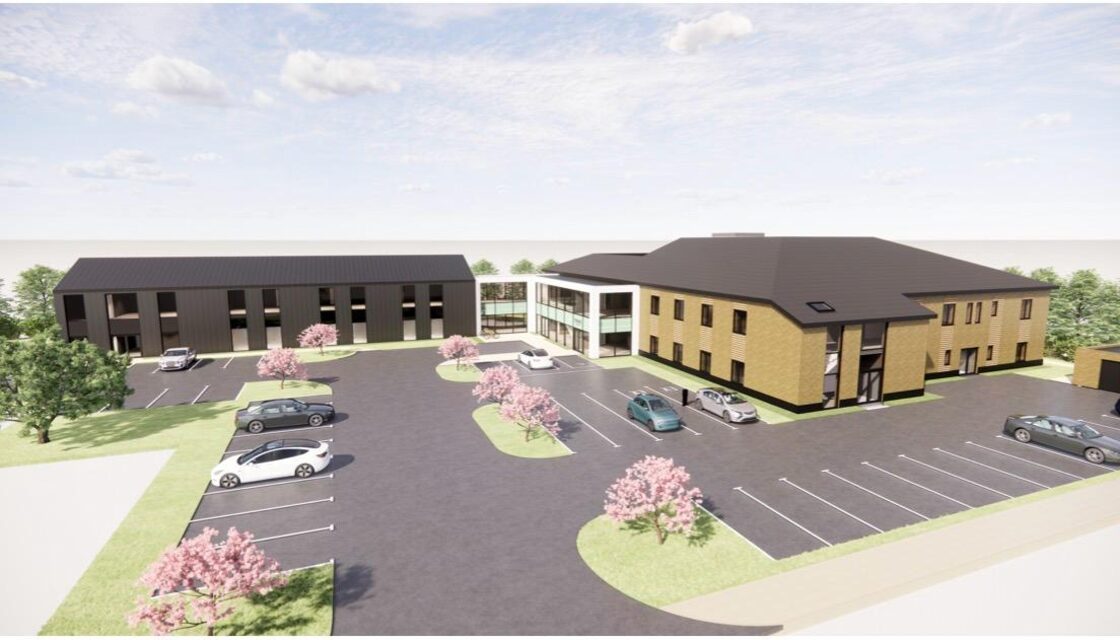 Visualisation of the micro hospital: a two-storey brick block and a darker clad wing joined by a glazed entrance, with parking to the front